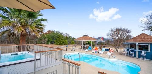 a large swimming pool with chairs and a house at Scenic 5-Acre Retreat with Hot Tub Pool & Game Room in Manor