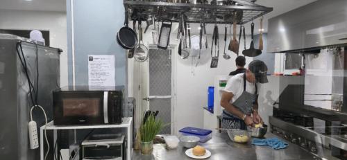 a man standing in a kitchen preparing food at Leribi Suites and Restaurant in Ulot