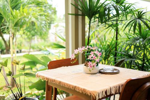 a table with a vase of flowers on it at Bang Po Botanica in Surat Thani