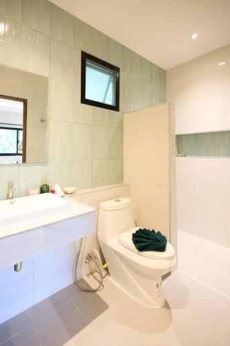 a bathroom with a toilet and a sink at Bang Po Botanica in Surat Thani