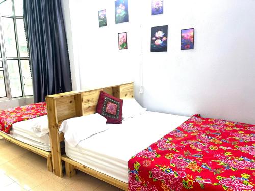 a bedroom with two twin beds with red sheets at Bảo Bảo guest houes in Bắc Hà