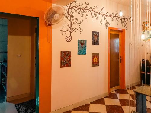 a hallway with an orange wall with pictures on it at Bonita Chillhouse in Aswan