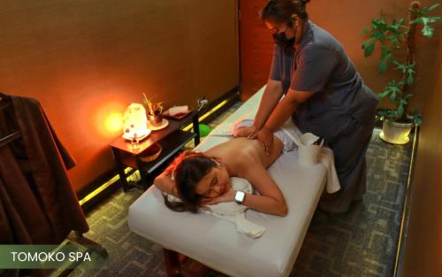 a woman getting a massage in a bath tub at Acacia Hotel Manila in Manila