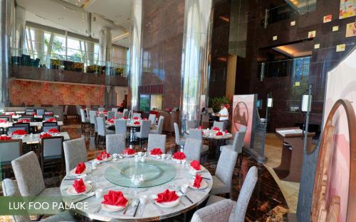 a restaurant with tables and chairs with red roses on them at Acacia Hotel Manila in Manila