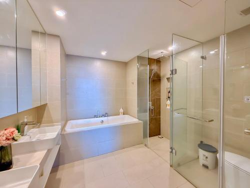 a bathroom with a tub and a sink and a shower at The Sóng Apartment Vũng Tàu - Căn Hộ Hồ Bơi-Olive Homestay in Vung Tau