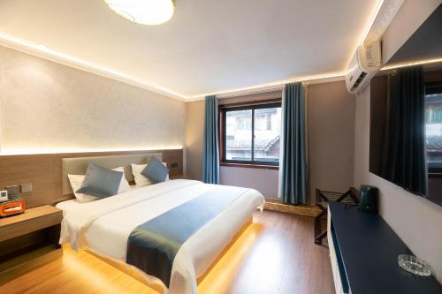 a hotel room with a large bed and a television at Shuiyun Zhijian Homestay in Fenghuang