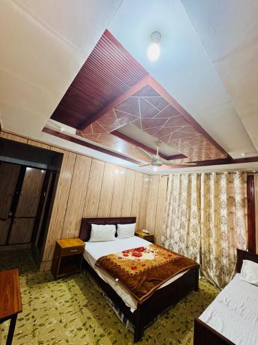 a bedroom with a bed in a room with a ceiling at travel and tour in Skardu