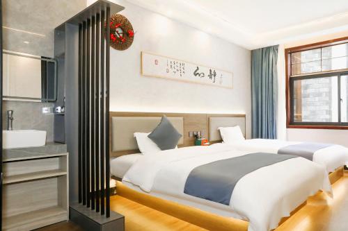 a bedroom with two beds and a sink at Shuiyun Zhijian Homestay in Fenghuang