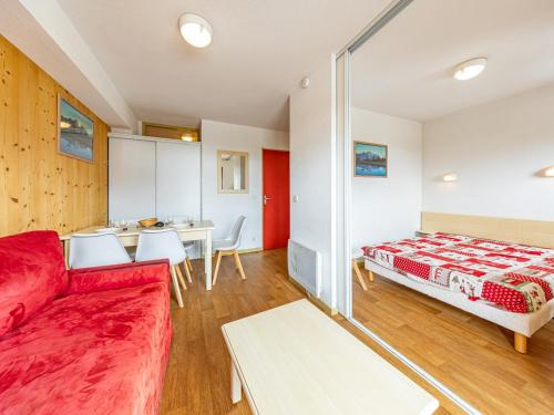 a living room with a red couch and a bed at Appartement 6 pers aux pieds des pistes à Saint-François-Longchamp - FR-1-807-29 in Saint-François-Longchamp