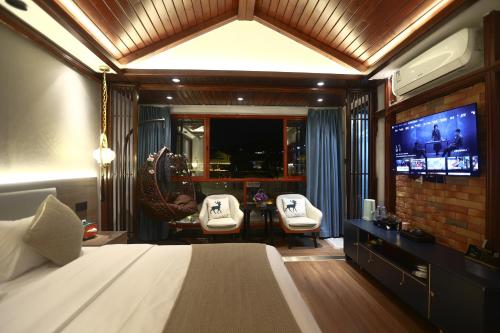 a bedroom with a bed and a flat screen tv at Shuiyun Zhijian Homestay in Fenghuang