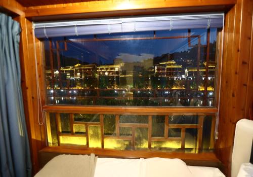 a window with a view of a city at Shuiyun Zhijian Homestay in Fenghuang