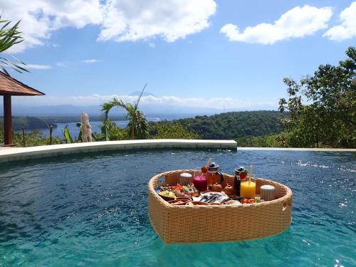 ペニダ島にあるMimpi Villas - Private Luxury & Romantic Villa with seaviewのプールにあるタオルやその他のアイテムの入ったバスケット