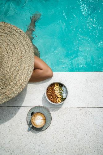 a person sitting next to a pool with a bowl of food at Kasih 2 - Villa with private pool in Gili T in Mantaak