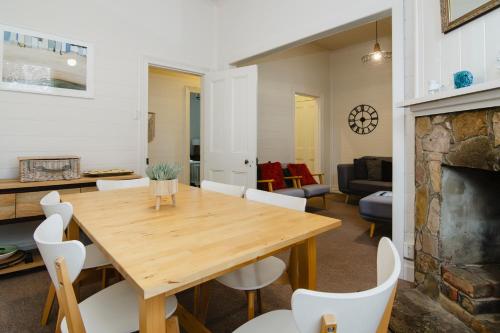 a dining room and living room with a wooden table and chairs at Clifftop Cottage at The Portsea Camp in Portsea