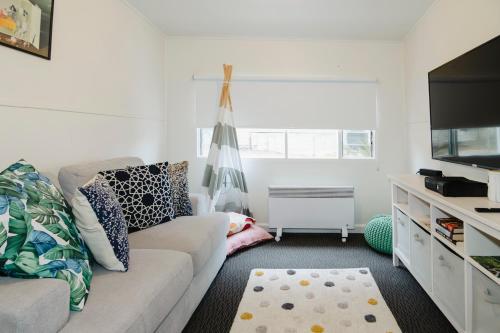a living room with a couch and a flat screen tv at Clifftop Cottage at The Portsea Camp in Portsea
