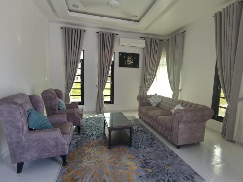 a living room with two couches and a coffee table at Teratak Naila in Kuala Terengganu
