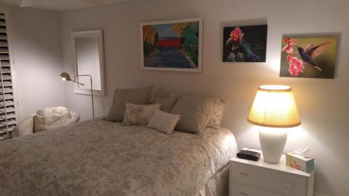 a bedroom with a bed with a lamp and pictures on the wall at Spectacular View Just Steps to Pool and Jacuzzi at Sunrise Country Club in Rancho Mirage