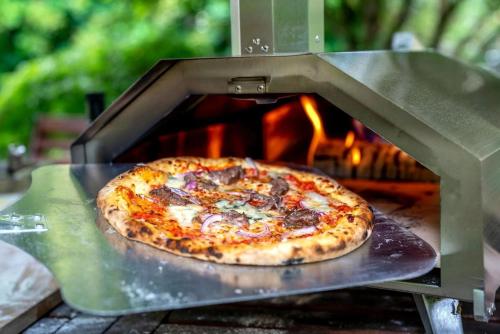 a pizza is being cooked in a pizza oven at Golden Caves - Bed and Breakfast in Takaka