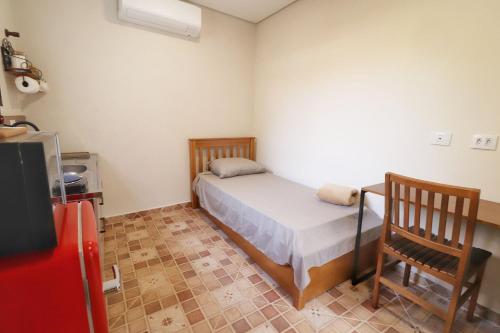 a small bedroom with a bed and a chair at Estúdio VI - Franco da Rocha in Franco da Rocha