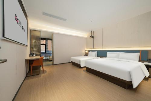 a hotel room with two beds and a desk at Yizhi Hotel - Guangzhou Shamian Island Huangsha Metro Station-Canton Fair free shuttle bus included Breakfast in Guangzhou
