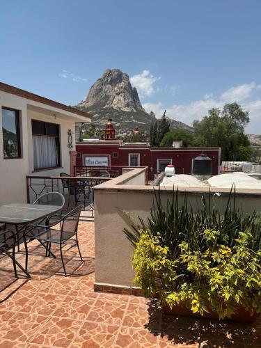 a patio with a table and chairs and a mountain at Hotel del Centro in Bernal