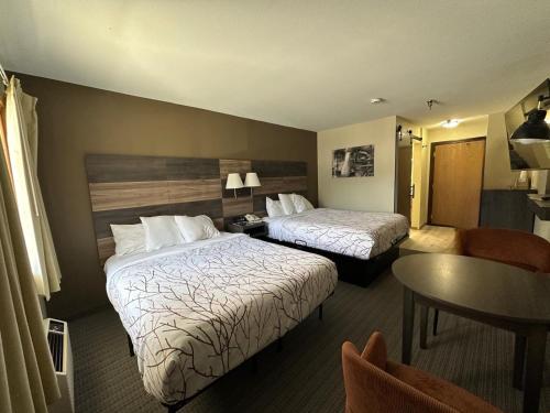 a hotel room with two beds and a table at Roosevelt Inn Mount Rushmore in Keystone