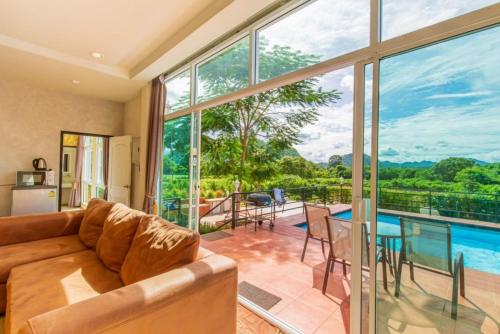 a living room with a couch and a view of a pool at The X10 Nordic Tent and Glamping Pool Villa Khaoyai เขาใหญ่ - SHA Certified in Ban Thung Sawang