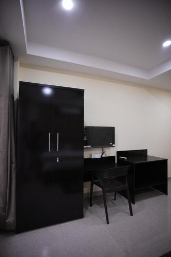 Armario negro en una habitación con escritorio en ARARA GROUP Inn, en Cherrapunji