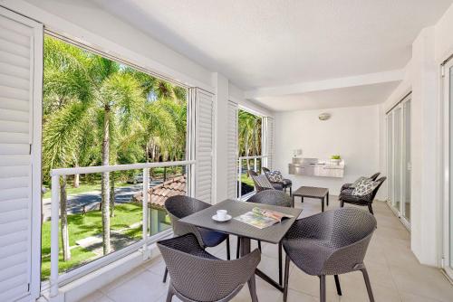 a dining room with a table and chairs and a large window at Peppers Beach Club in Port Douglas
