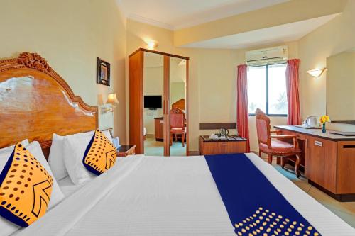 a hotel room with a large bed and a desk at Super Capital O Indrapuri Rajadhani in Trivandrum
