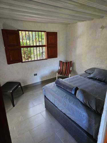 a bedroom with a bed and a window and a chair at Don tranquilo in Alejandría