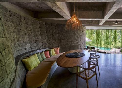 a room with a couch with a table and chairs at Chameleon Villa Bali in Tabanan