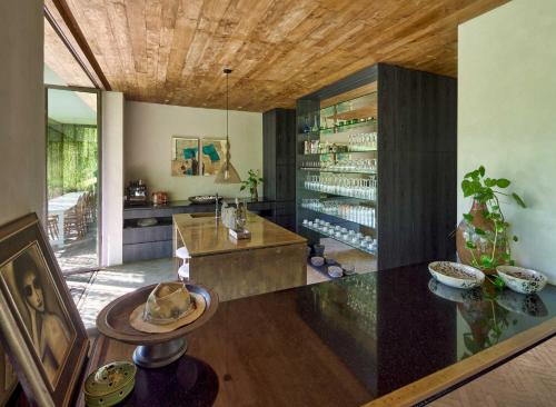 a kitchen with a glass counter and a dining room at Chameleon Villa Bali in Tabanan