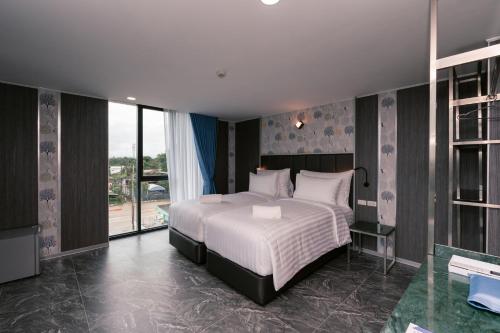 a bedroom with a bed and a large window at วัน บัดเจท เชียงราย บ้านใหม่ in Chiang Rai