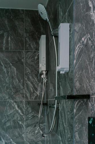 a shower with a shower head in a bathroom at วัน บัดเจท เชียงราย บ้านใหม่ in Chiang Rai