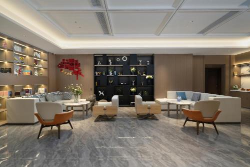 a lobby with couches and tables and chairs at Yizhi Hotel - Guangzhou Shamian Island Huangsha Metro Station-Canton Fair free shuttle bus included Breakfast in Guangzhou