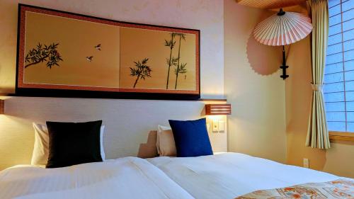 a bedroom with a bed and a painting on the wall at Kyoto Inn Gion in Kyoto