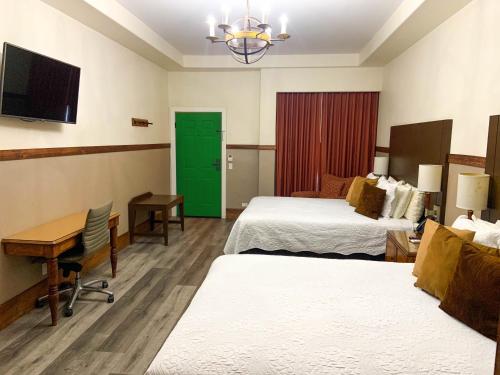 a hotel room with two beds and a desk at Hotel Hacienda Santana in Tecate