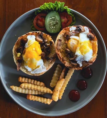 Un plato con dos sándwiches de desayuno y papas fritas. en Singabu Bungalows, en Nusa Penida