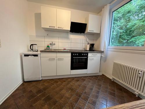 a small kitchen with white appliances and a window at Stay 15 Kassel in Kassel