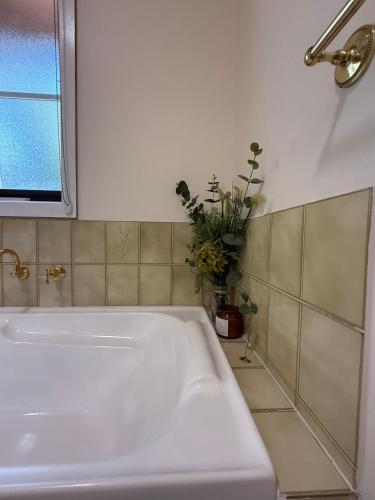 a white bath tub in a bathroom with a window at Two Mountains Lodge - Modern Alpine Retreat with Spa - 3mins to Mt Buller in Mount Buller