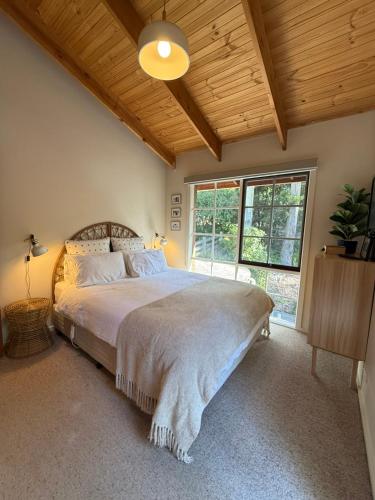 a bedroom with a large bed and a large window at Two Mountains Lodge - Modern Alpine Retreat with Spa - 3mins to Mt Buller in Mount Buller