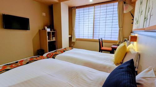 a hotel room with two beds and a window at Kyoto Inn Gion in Kyoto
