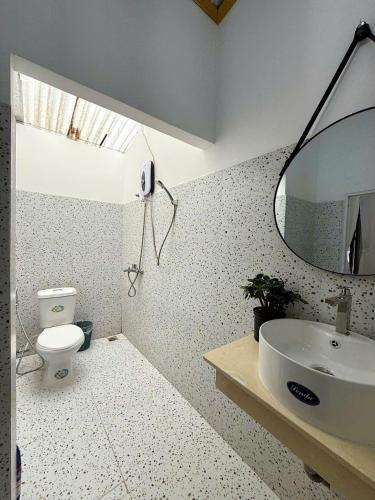 a bathroom with a sink and a toilet and a mirror at RoBin's Home in Da Thanh
