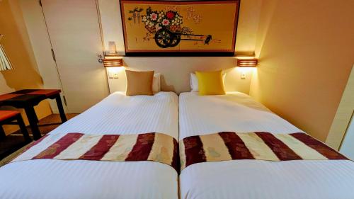 two beds sitting next to each other in a room at Kyoto Inn Gion in Kyoto
