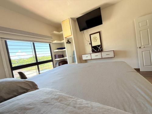 a bedroom with a large bed and a large window at Private jacuzzi pool 2 level house private coto in Mezcales