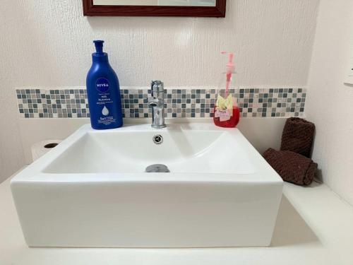 a white sink with a blue bottle on top of it at Private jacuzzi pool 2 level house private coto in Mezcales