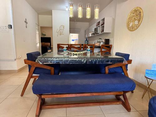 a dining room with a glass table and blue chairs at Private jacuzzi pool 2 level house private coto in Mezcales