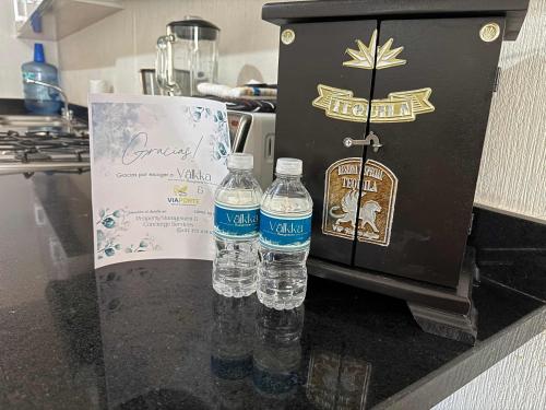 two bottles of water sitting on top of a counter at Private jacuzzi pool 2 level house private coto in Mezcales
