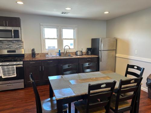 a kitchen with a table and a kitchen with a refrigerator at JD Apartment and House in Seaside Heights